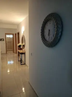 a clock hanging on a wall in a hallway at New, Modern, and Cozy 3 Bedroom Apartment. in Santa Maria