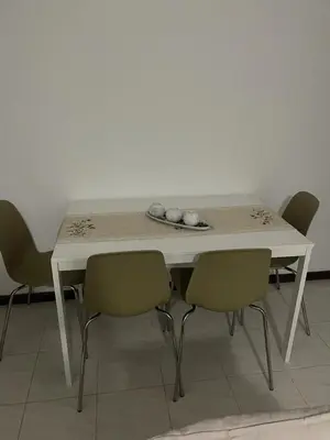 a white table with four chairs around it at Apartamento Vila Santa Bárbara ,Bloco F RChão Dirt,Santo Antão,Cabo Verde in Mão para Trás