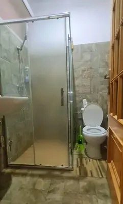 a bathroom with a shower with a toilet and a sink at Helton´s Residence in Praia
