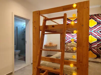 a bunk bed with a ladder in a room at Kyaala Suítes - pool & sea view in Praia