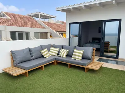 a couch with pillows sitting on a lawn in front of a house at New Rooftop Gem with stunning Oceanview in Santa Maria