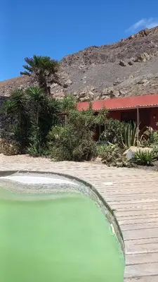 a large pool of green water on a wooden deck at Casa Azul in Mindelo
