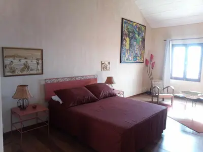 a bedroom with a bed with a red bedspread at Casa Azul in Mindelo