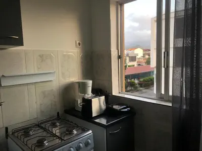 a kitchen with a stove and a window at Apartamento T2-Dunas Centro in Tarrafal