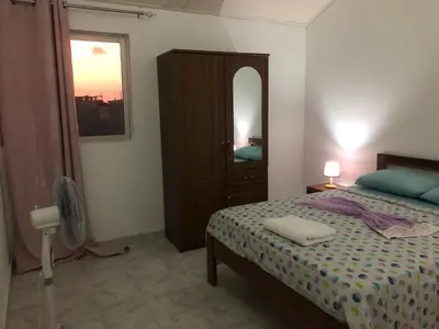 a bedroom with a bed and a dresser and a mirror at Apartamento T2-Dunas Centro in Tarrafal
