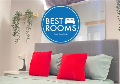 a sign that is above a bed with red pillows at Best Rooms - Quarto 3 Plateau in Praia