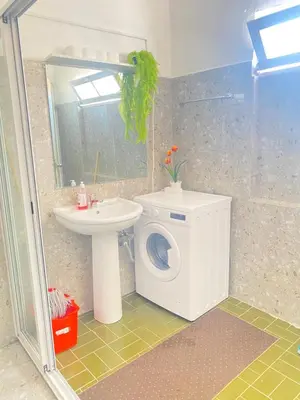 a bathroom with a washing machine and a sink at Best Rooms- Quarto 2 Plateau in Praia