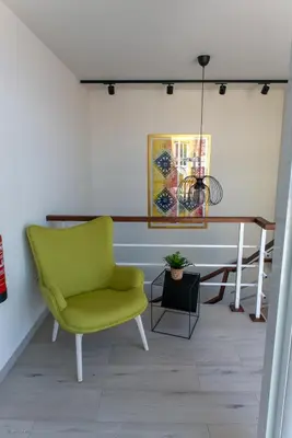 a living room with a green chair and a table at Santa Cruz Boutique Hotel in Mindelo