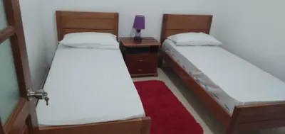 two twin beds in a room with a red rug at Repousando in Mão para Trás