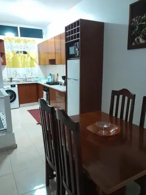 a kitchen with a wooden table and a dining room at Repousando in Mão para Trás