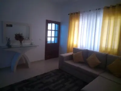 a living room with a couch and a table and a window at Repousando in Mão para Trás