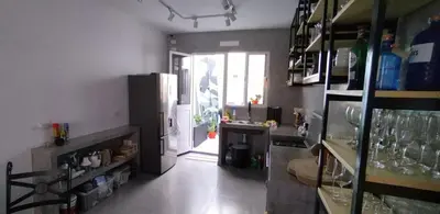 a kitchen with a refrigerator and a door to a room at Apart Laginha Tess & To in Mindelo