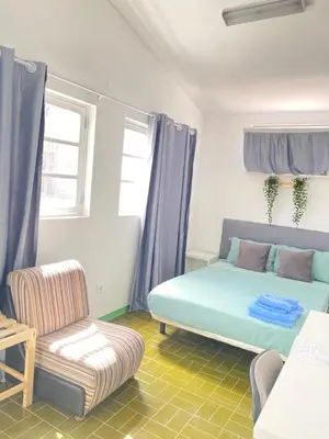 a room with a bed and a couch and a chair at Best Rooms - Quarto 1 Plateau in Praia