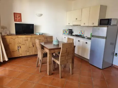 a kitchen with a table and chairs and a refrigerator at Beach front ocean view Porto Antigo2 Santa Maria in Santa Maria