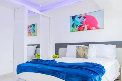 a white bedroom with a blue blanket on a bed at Sea View Big Lanche in Praia Baixo