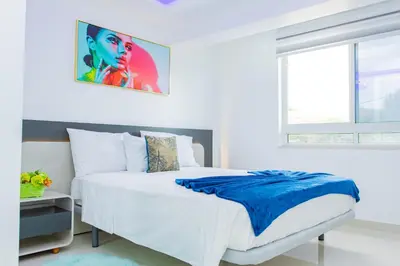 a white bedroom with a bed with a blue blanket at Sea View Big Lanche in Praia Baixo