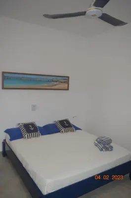 a bed in a room with a ceiling fan at LA VELA in Palmeira