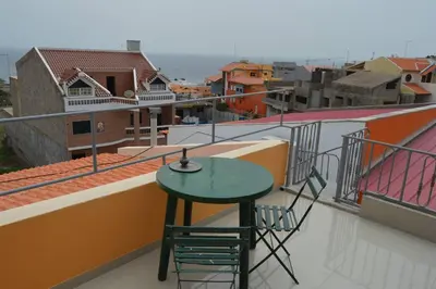 a table and chairs on the balcony of a building at Apartamento t1 mobiliado com Wi-Fi in Praia