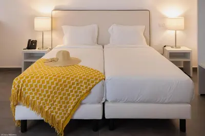 two beds with a hat sitting on top of them at Oasis White Hotel in Sal Rei