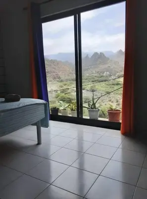 a room with a window with a view of a mountain at Casa Familiar Pôr do Sol in Ribeira Grande