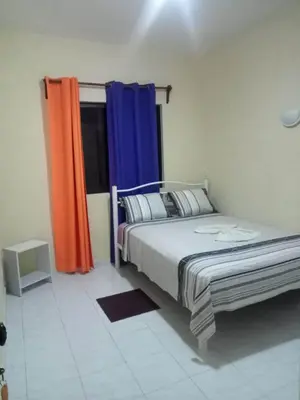 a bedroom with a bed and a window with curtains at Casa Familiar Pôr do Sol in Ribeira Grande