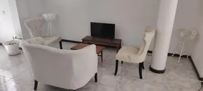 a living room with two chairs and a television at Maya Apartments in Mindelo