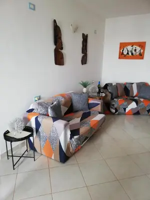 a living room with a couch and a table at Adult only beachfront 2 bedroom apartment Santa Maria airport pick up, aircon, unlimited wifi ideal for remote working and long stay in Santa Maria