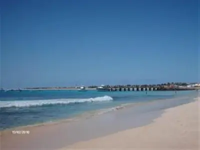 a beach with a group of people in the water at Adult only beachfront 2 bedroom apartment Santa Maria airport pick up, aircon, unlimited wifi ideal for remote working and long stay in Santa Maria