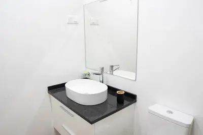 a white bathroom with a sink and a mirror at 3 bdr aprt, best seaview, rooftop pool - LCGR in Praia