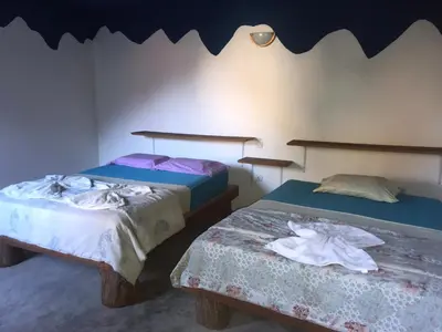 two beds sitting next to each other in a room at Pensão Repouso Alegre Turismo e Aventura in Portela