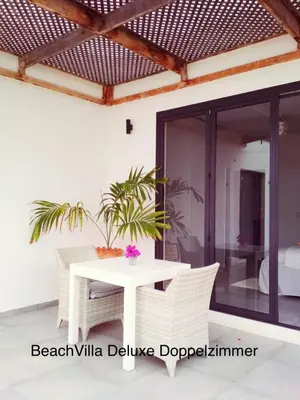 a patio with a white table and chairs at Luxury Beach Villa, Praia de Chaves, Boa Vista in Boa Ventura