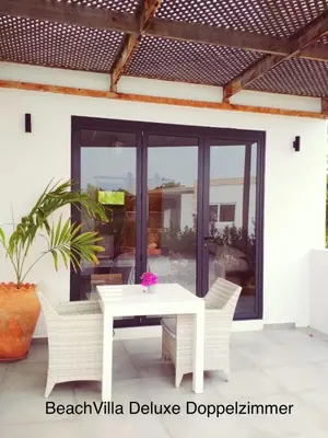 a patio with a white table and chairs at Luxury Beach Villa, Praia de Chaves, Boa Vista in Boa Ventura