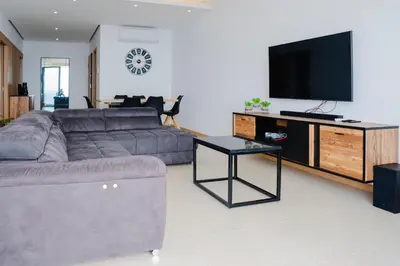 a living room with a couch and a flat screen tv at 3 bdr aprt, amazing seaview, rooftop pool - LCGR in Praia
