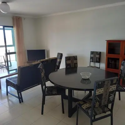 a dining room with a black table and chairs at Recanto Verde Cara in Mindelo