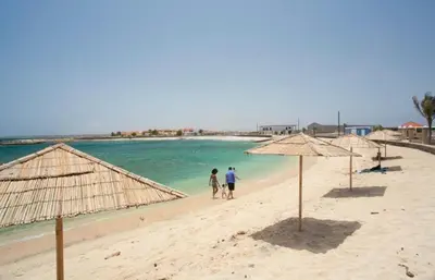 a group of people walking on a beach with umbrellas at Murdeira Village V155A in Beirona