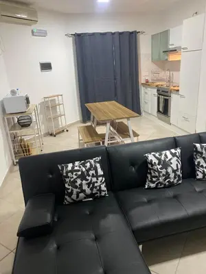a living room with a black couch and a table at Murdeira Village V155A in Beirona