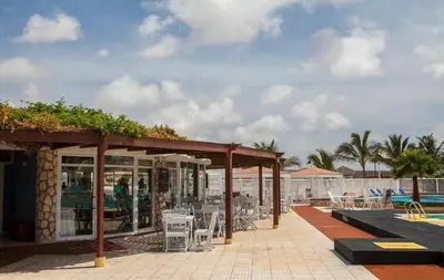 a patio with tables and chairs next to a pool at Murdeira Village V155A in Beirona