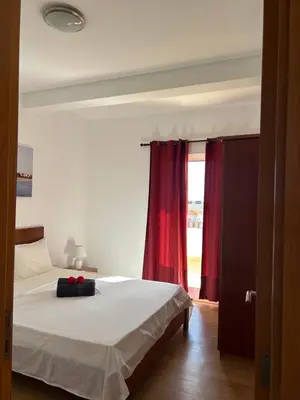 a bedroom with a bed with a red curtain at Casa Maria Apartments in Santa Maria