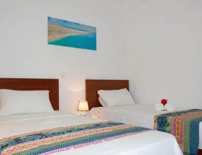 two beds in a room with white walls at Casa Maria Apartments in Santa Maria