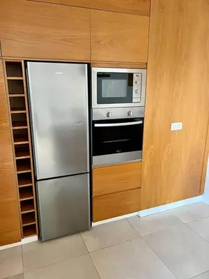 a kitchen with a stainless steel refrigerator and a microwave at Kriol Guest House in Praia