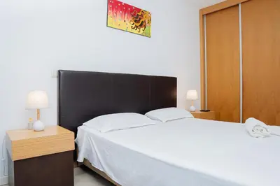 a bedroom with a large white bed and two lamps at Kriol Guest House in Praia