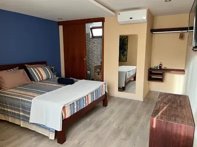 a bedroom with a bed and a table in it at Orietta Residencial in Mindelo
