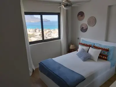 a bedroom with a bed with a large window at Bellavista in Mindelo