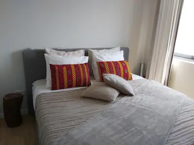 a bed with three pillows on top of it at Bellavista in Mindelo