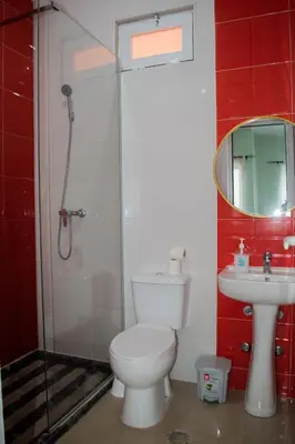 a bathroom with a toilet and a shower and a sink at Comfortable and Cozy Apartments in Praia