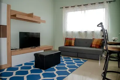 a living room with a couch and a tv at Comfortable and Cozy Apartments in Praia