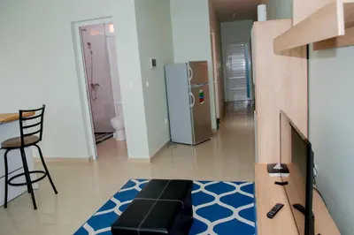 a living room with a refrigerator and a table and stool at Comfortable and Cozy Apartments in Praia