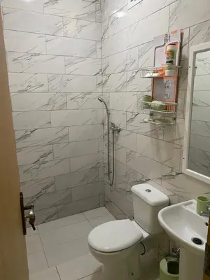 a bathroom with a toilet and a sink and a shower at Aluguer apartamento in Santa Maria