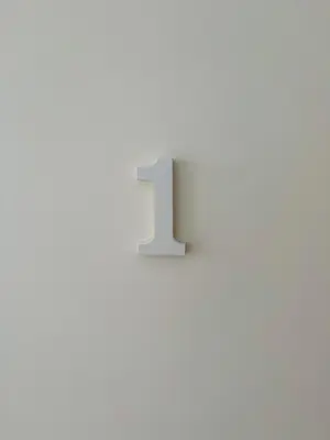a white number one on a white wall at KAZARÃO DI MAVETE- Guesthouse in Praia