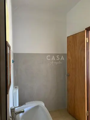 a bathroom with a toilet and a sign on the wall at Residencial Casa Ângela in Espargos